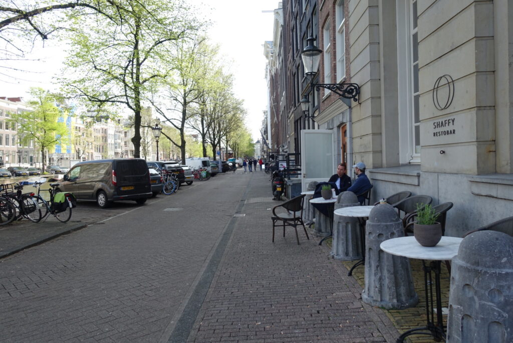 The sidewalk in front of Felix Meritis is narrow and made of brick. Curb cuts are at the ends of the blocks.
